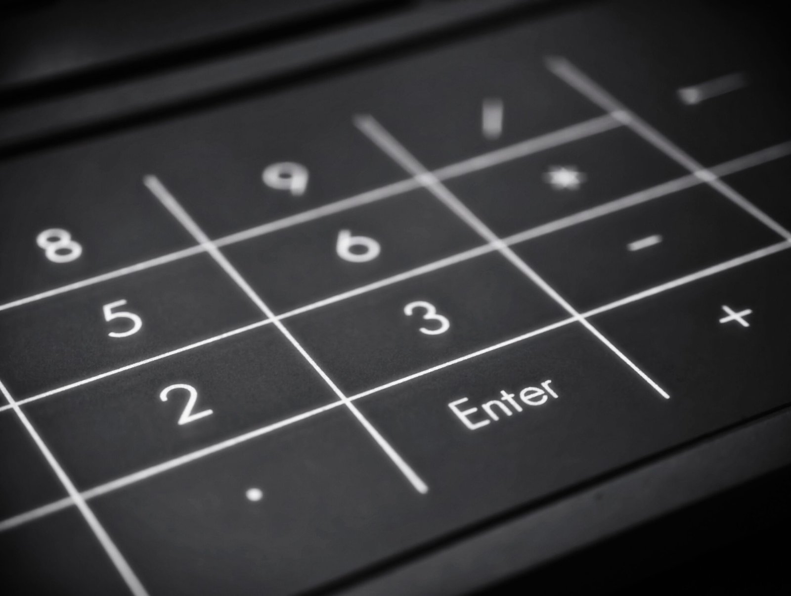 Black and white image of a numeric keypad highlighting the Enter key.